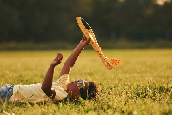 Liggen Met Speelgoed Vliegtuig Het Gras Afrikaans Amerikaans Kind Veel — Stockfoto