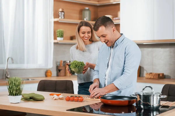 テーブルのそばに立っている男 カップル調製食品に自宅でザモダンキッチン — ストック写真