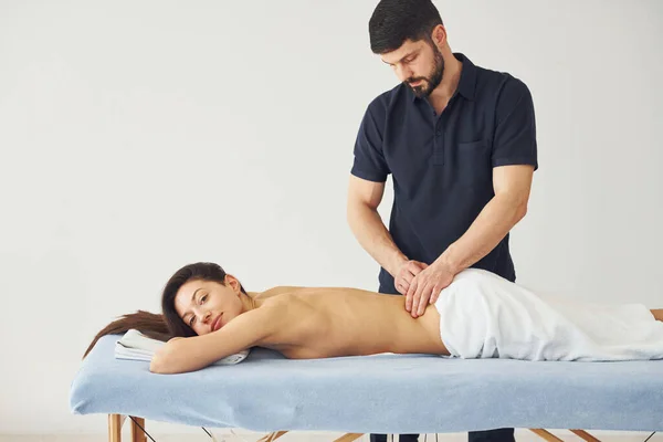 Jovem Mulher Está Deitada Quando Homem Fazendo Massagem Suas Costas — Fotografia de Stock