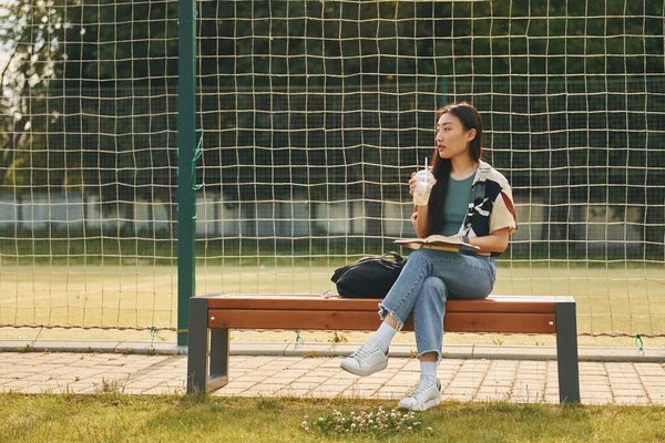 Sitzt Gegen Den Sportplatz Junge Asiatische Frau Ist Tagsüber Draußen — Stockfoto