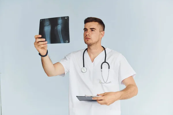 Con Estetoscopio Joven Médico Masculino Uniforme Está Interior Contra Fondo — Foto de Stock