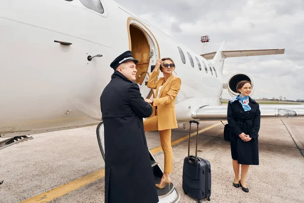 Екіпаж Літака Веде Жінку Жовтому Одязі Всередині Літака — стокове фото