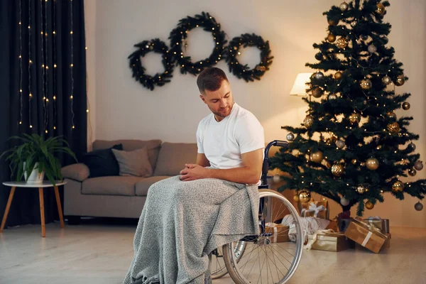 New year is coming. Disabled man in wheelchair is at home.