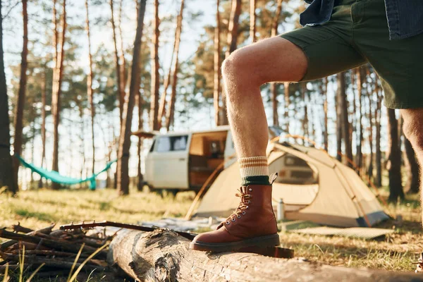 Close up view of legs. Man is traveling alone in the forest at daytime at summer.