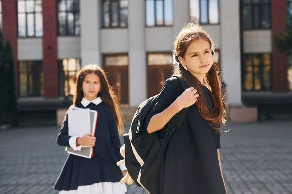 正面図 2人の女子高生が校舎の近くにいる — ストック写真