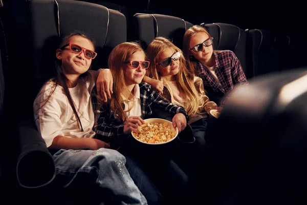 在黑暗的房间里一群坐在电影院一起看电影的孩子 — 图库照片