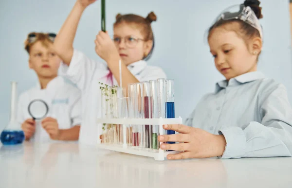 Παιδιά Λευκά Παλτά Παίζουν Έναν Επιστήμονα Στο Εργαστήριο Χρησιμοποιώντας Εξοπλισμό — Φωτογραφία Αρχείου