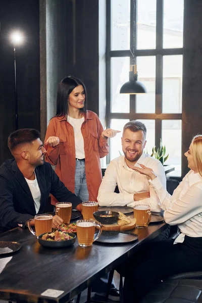 Essen Gruppe Junger Freunde Sitzt Mit Bier Bar Zusammen lizenzfreie Stockfotos