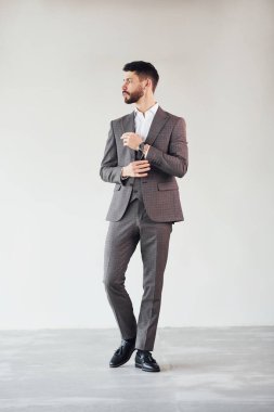 Beyaz arka planda kamera için poz vermek. Takım elbiseli genç bir işadamı..