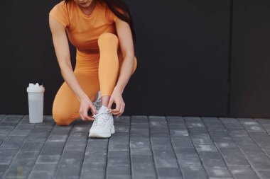 Bağcıklar. Spor giyimli genç bir kadının dışarıda spor seansı var..