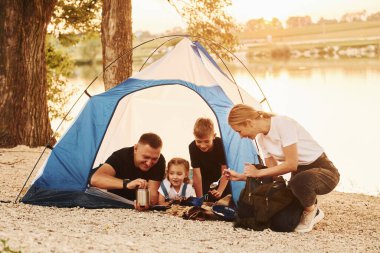 Tatil kavramı. Anne, baba ve çocukların ailesi kampta..