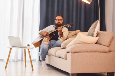 Rahatlamış hissediyorum. Gündelik giysiler içinde ve akustik gitarlı bir adam içeride..