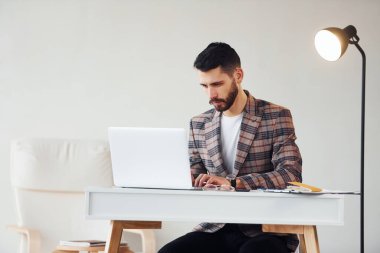 Laptop kullanıyor. Takım elbiseli genç bir iş adamı. Başarı kavramı.