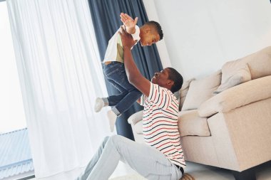 Aktif hafta sonu harcamaları. Afrikalı Amerikalı baba ve küçük oğlu evde..