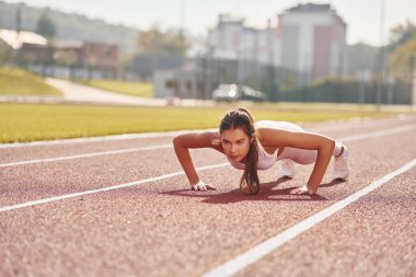 Vücut bakımı kavramı. Spor elbiseli genç bayan dışarıda egzersiz yapıyor..