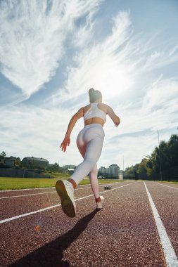 Spor elbiseli aktif genç bayan dışarıda egzersiz yapıyor..