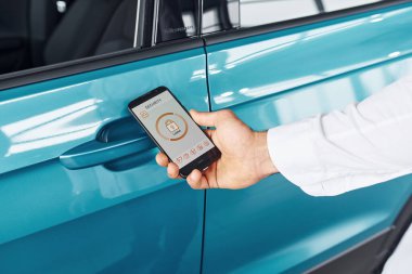 Etiketli ve simgeli telefonları tutan adamın elini yakından izle. Uzaktan kumanda kavramı.
