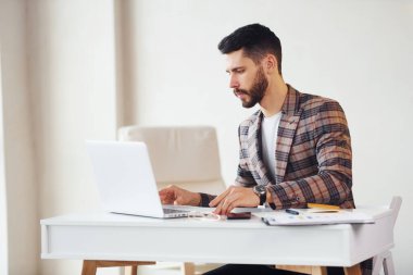 Laptop kullanıyor. Takım elbiseli genç bir iş adamı. Başarı kavramı.