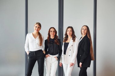 Resmi giysiler içinde ofiste birlikte olan bir grup yetişkin kadın..