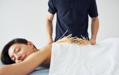 Özel ekipman. Genç bir kadın, erkek kaplıcada vücuduna masaj yaparken uzanır..