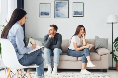 Çift kanepede oturuyor ve kadın psikologla çalışıyor..