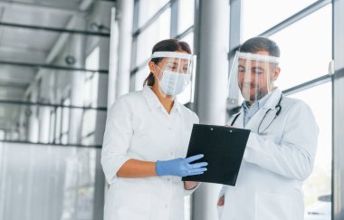 Meşgul insanlar. Beyaz önlüklü iki doktor klinikte birlikte çalışıyorlar..