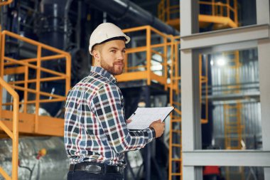 Mühendis içeride. Üniformalı inşaat işçisi fabrikada..