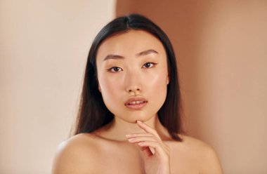 İçerde duran ciddi Asyalı genç bir kadının portresi..