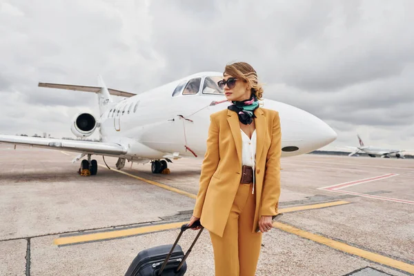 Жовтому Одязі Молода Жінка Багажем Знаходиться Відкритому Повітрі Біля Літака — стокове фото