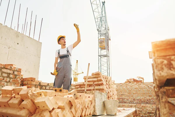 Jovem Trabalhador Construção Uniforme Está Ocupado Edifício Inacabado — Fotografia de Stock