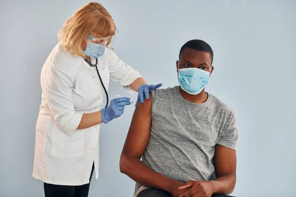 Senior Doctor Giving Injection Young African American Man Hospital — Stock fotografie