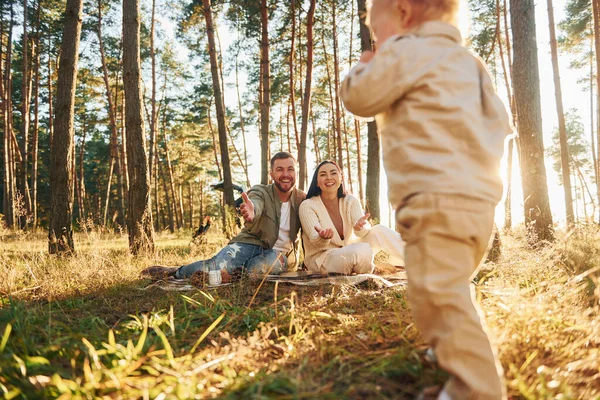 女の子が走っている 父と母と娘の幸せな家族が森の中にいる — ストック写真