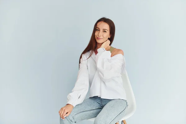 Beyaz Elbiseli Genç Bir Kadın Beyaz Arka Planda Oturuyor — Stok fotoğraf