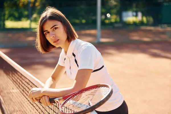 手里拿着球拍站着 女网球选手白天在球场上 — 图库照片