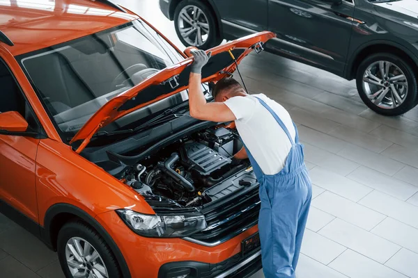 Orange Colored Car Man Uniform Repairing Broken Automobile Indoors — Stock Photo, Image