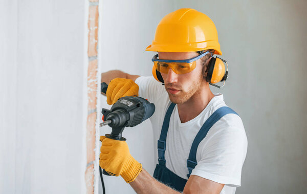 Portrait of young man working in uniform at construction at daytime.