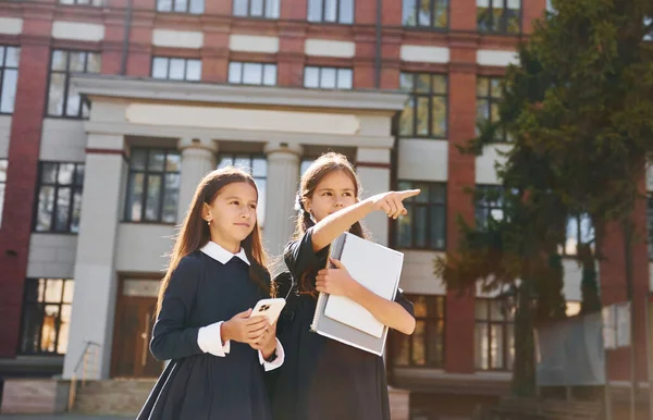 拿着书两个女学生一起在学校附近 — 图库照片