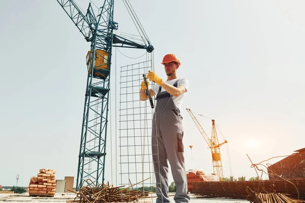 Crane Háttérben Van Egyenruhás Fiatal Építőmunkás Elfoglalt Befejezetlen Épületben — Stock Fotó