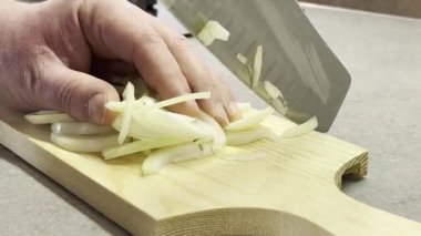 İtalyan adam soğan doğruyor.
