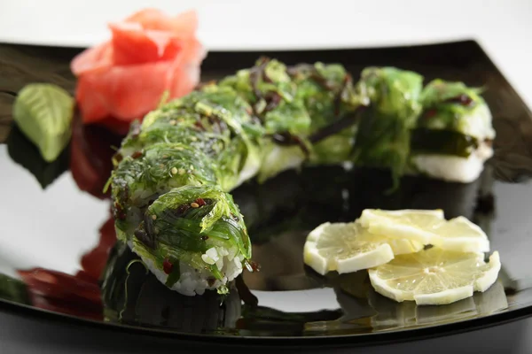 Frisches und schmackhaftes Sushi in schwarzer Schale — Stockfoto