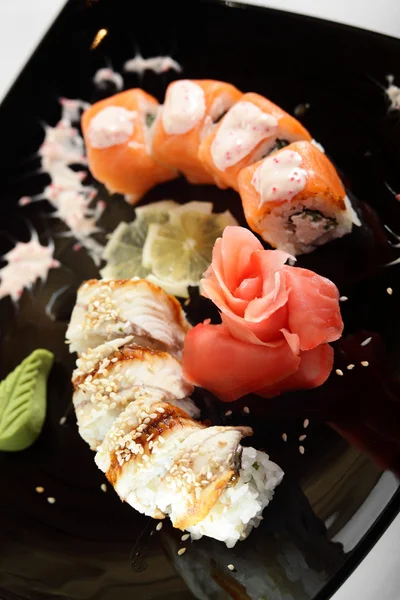 Fresh and tasty sushi in black dish — Stock Photo, Image