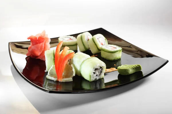 Fresh and tasty sushi in black dish — Stock Photo, Image