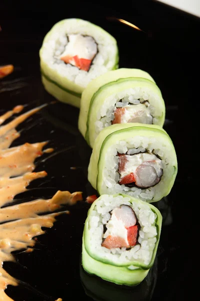 Färska och läckra sushi i svart maträtt — Stockfoto