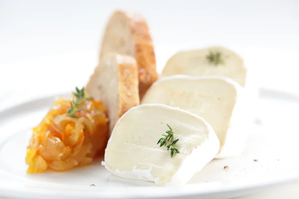 Peaces of cheese on white dish — Stock Photo, Image