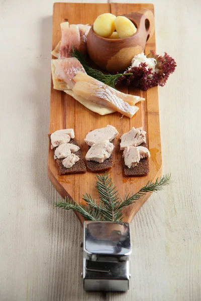 Assortimenti di pesce salato con patate su piatto di legno — Foto Stock