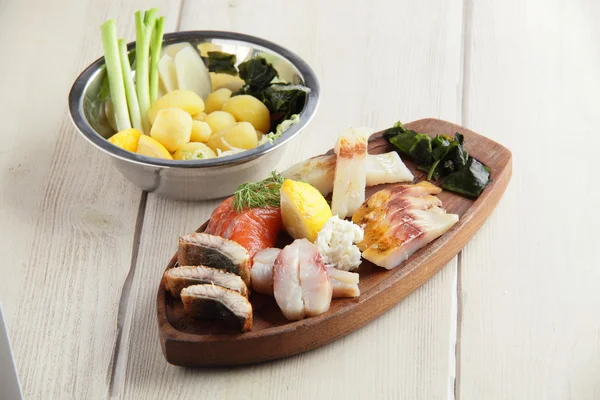 Salty fish assorti with potato on wooden plate — Stock Photo, Image