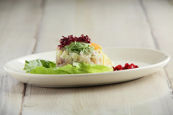 Салат из соленой рыбы на белой тарелке — стоковое фото