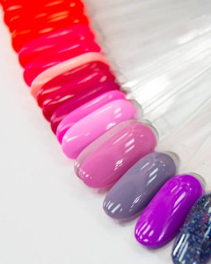 Çok renkli farklı palet jeli beyaz arkaplanda manikür örneklerini parlatır