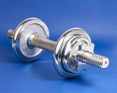 Koyu mavi arkaplan üzerinde paslanmaz metal dambıl metin için telif alanı