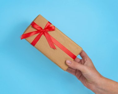 Mavi arka planda kırmızı fiyonklu hediye kutusu kağıdı.